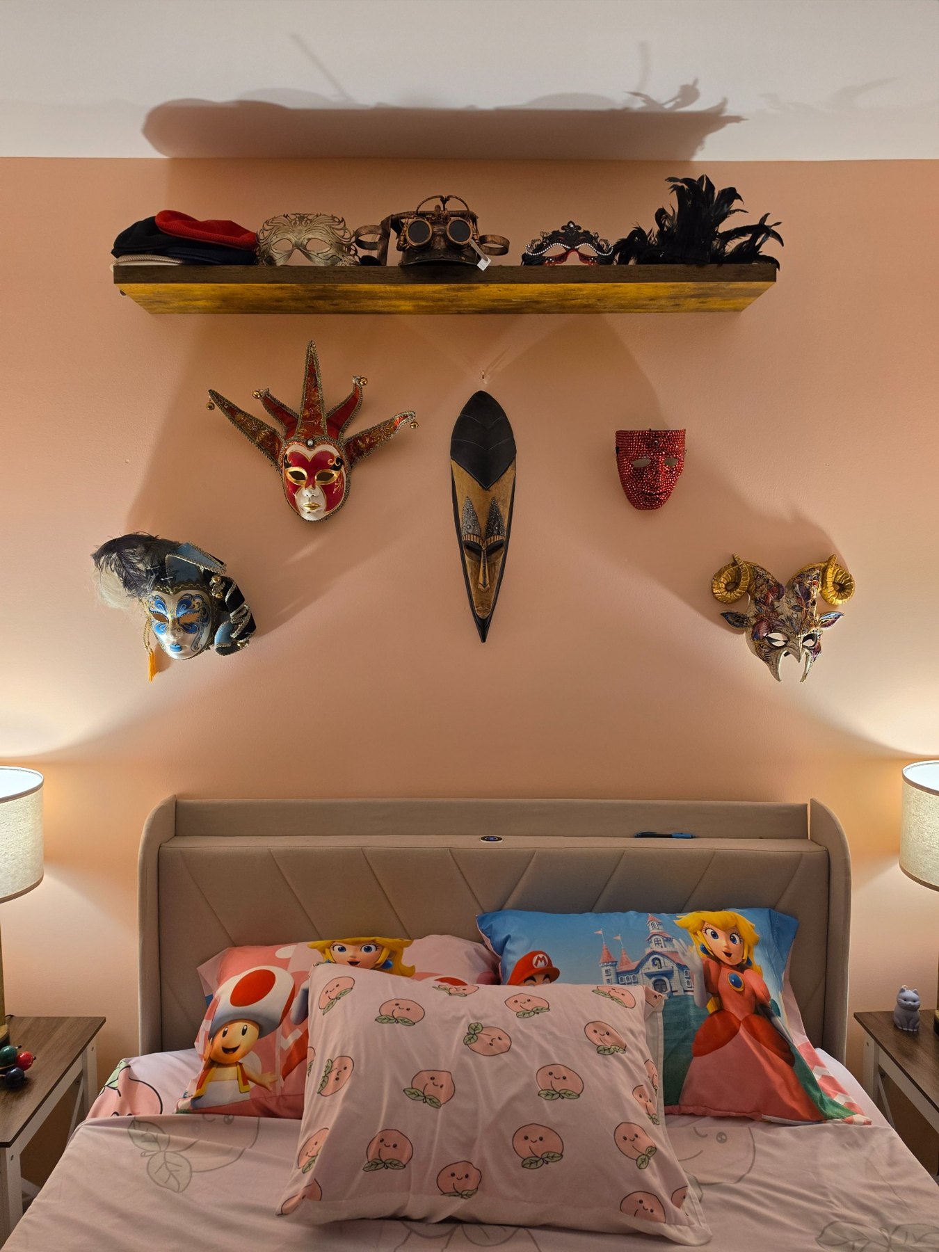 Masks displayed above the bed against peach walls