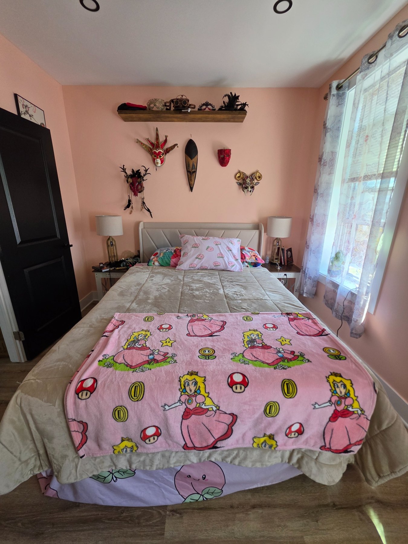 Daylight view of the bed with Princess Peach coverlet and masks above